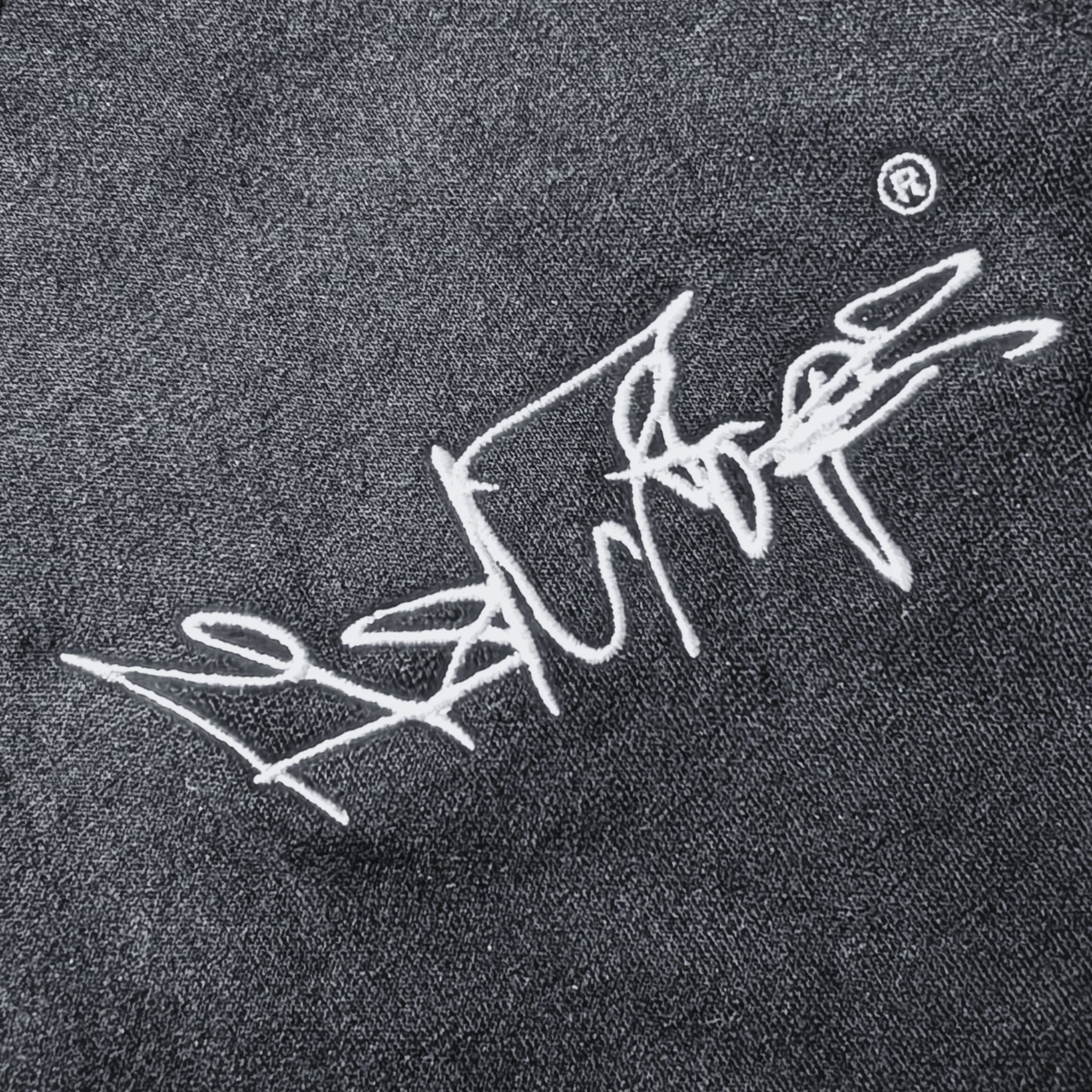 Nahaufnahme des gestickten MSNTRPZ® MISANTHROPZ® Signature-Logos auf dunklem Stoff im Noir-Stil; hochwertige Stickerei und strukturierte Textur | Premium German Streetwear