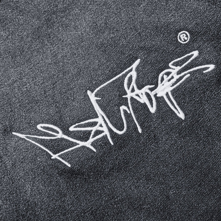 Nahaufnahme des gestickten MSNTRPZ® MISANTHROPZ® Signature-Logos auf dunklem Stoff im Noir-Stil; hochwertige Stickerei und strukturierte Textur | Premium German Streetwear