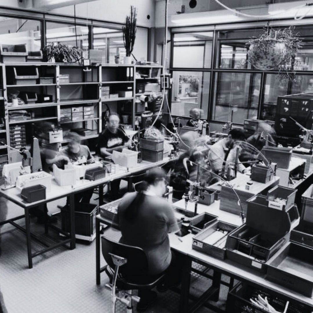 MSNTRPZ® MISANTHROPZ® Behind-the-Scenes Aufnahme eines Werkstatt- und Fulfillmentbereichs, in dem mehrere Personen an Verpackungs- und Produktionsschritten arbeiten | Premium German Streetwear