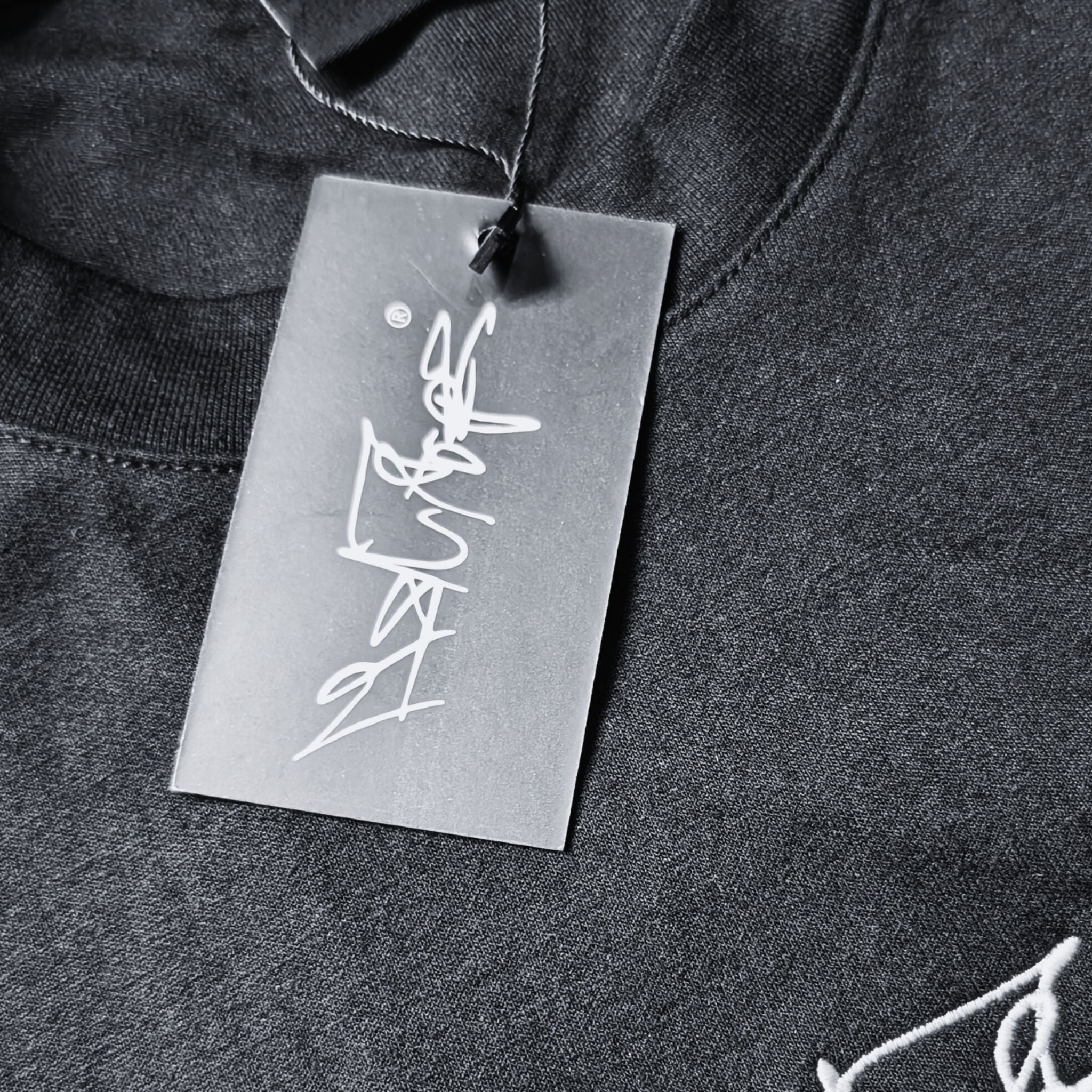 Nahaufnahme des MSNTRPZ® MISANTHROPZ® Hangtags mit weißem Signature-Schriftzug auf dunklem Stoff; hochwertiges Branding im Noir-Stil | Premium German Streetwear
