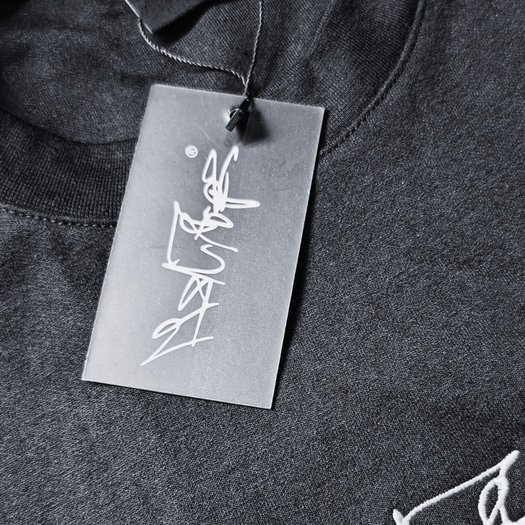 Nahaufnahme des MSNTRPZ® MISANTHROPZ® Hangtags mit weißem Signature-Schriftzug auf dunklem Stoff; hochwertiges Branding im Noir-Stil | Premium German Streetwear