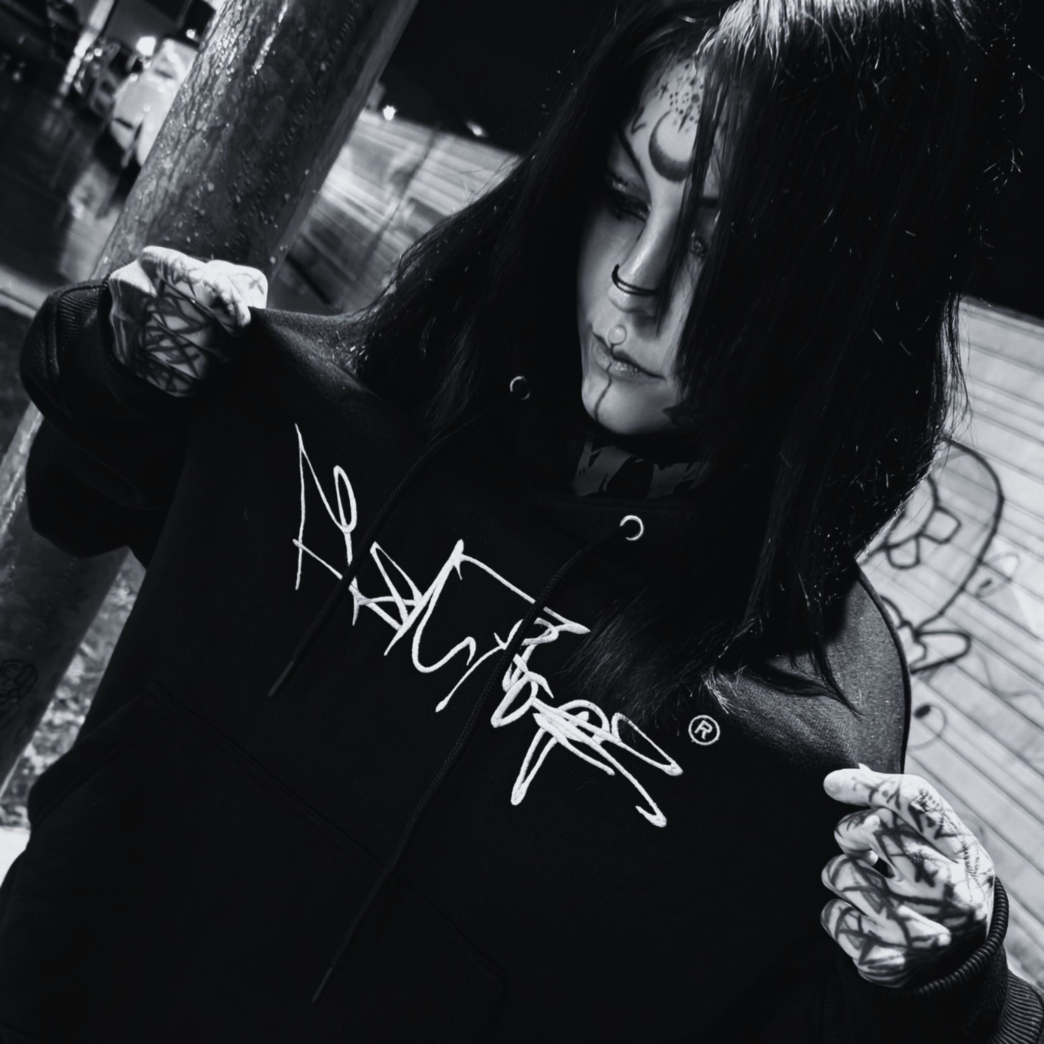 MSNTRPZ® MISANTHROPZ® Noir-Portrait eines Models, das den schwarzen Oversize-Hoodie mit markantem Frontprint präsentiert; urbaner Streetwear-Look | Premium German Streetwear