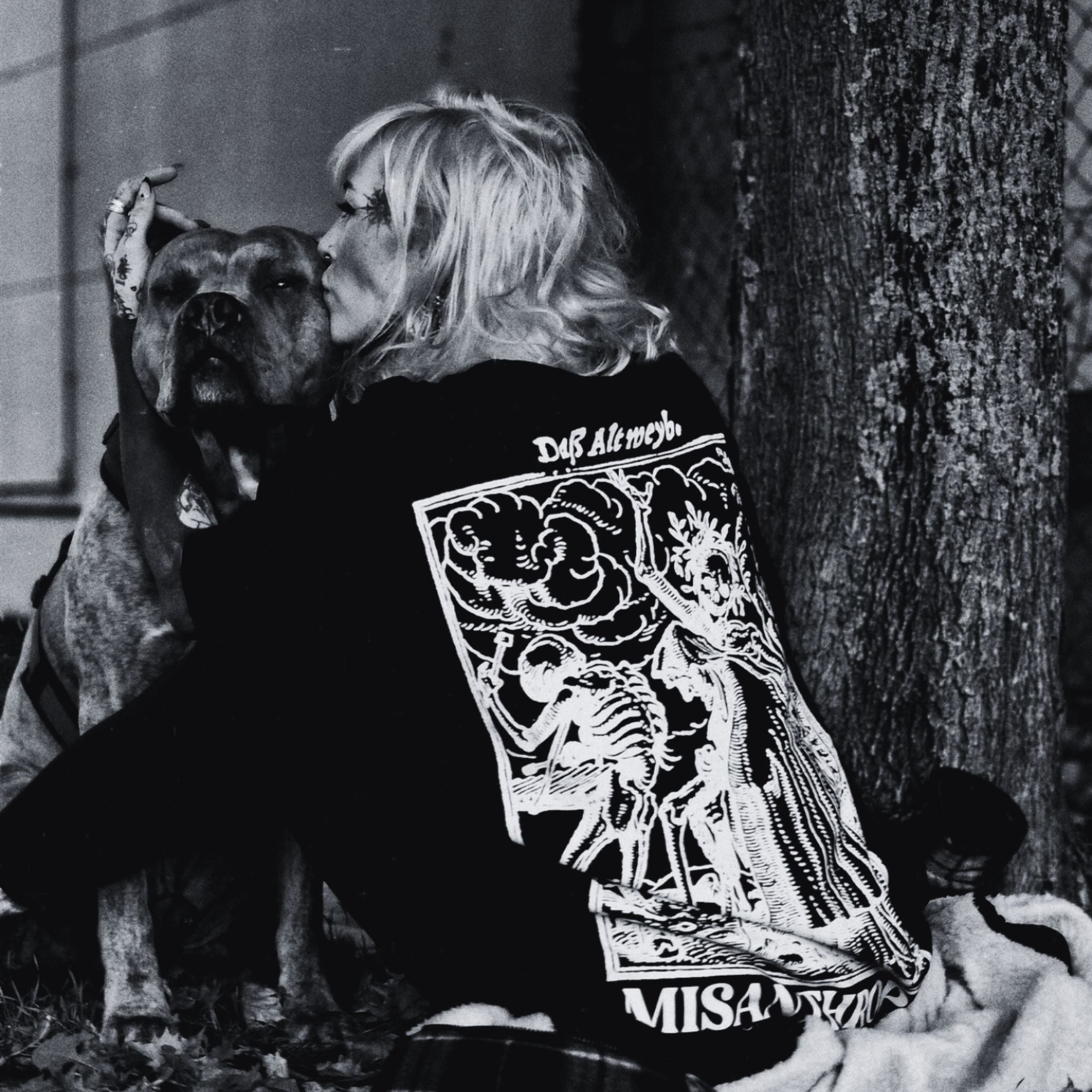 Frau im Noir-Look mit Hund, trägt MISANTHROPZ® Art-Backprint-Shirt; emotionaler Premium Streetwear-Moment