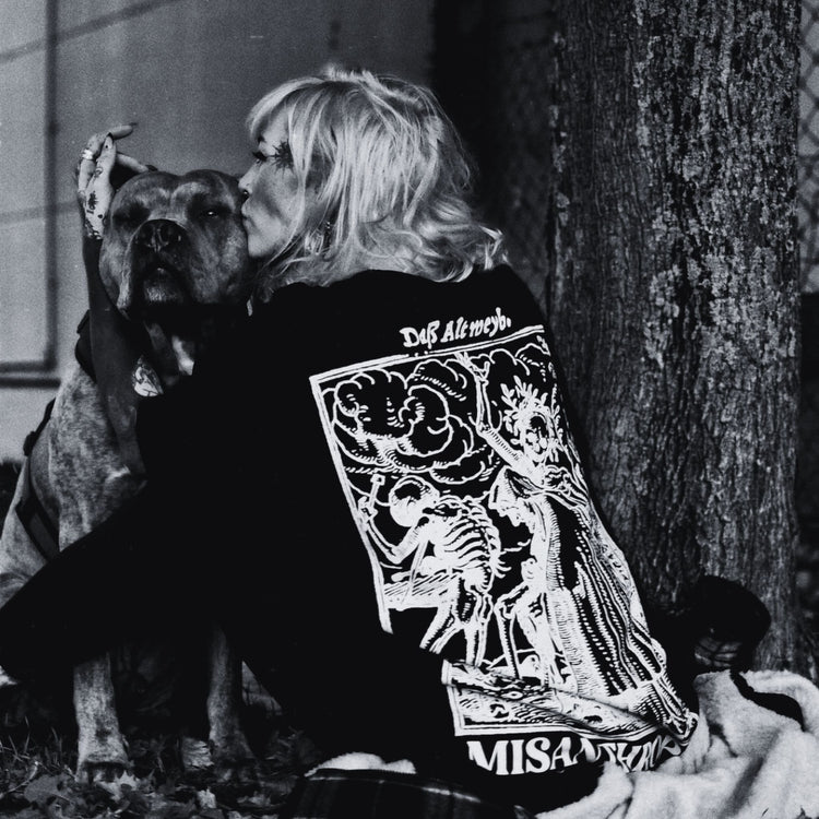 Frau im Noir-Look mit Hund, trägt MISANTHROPZ® Art-Backprint-Shirt; emotionaler Premium Streetwear-Moment