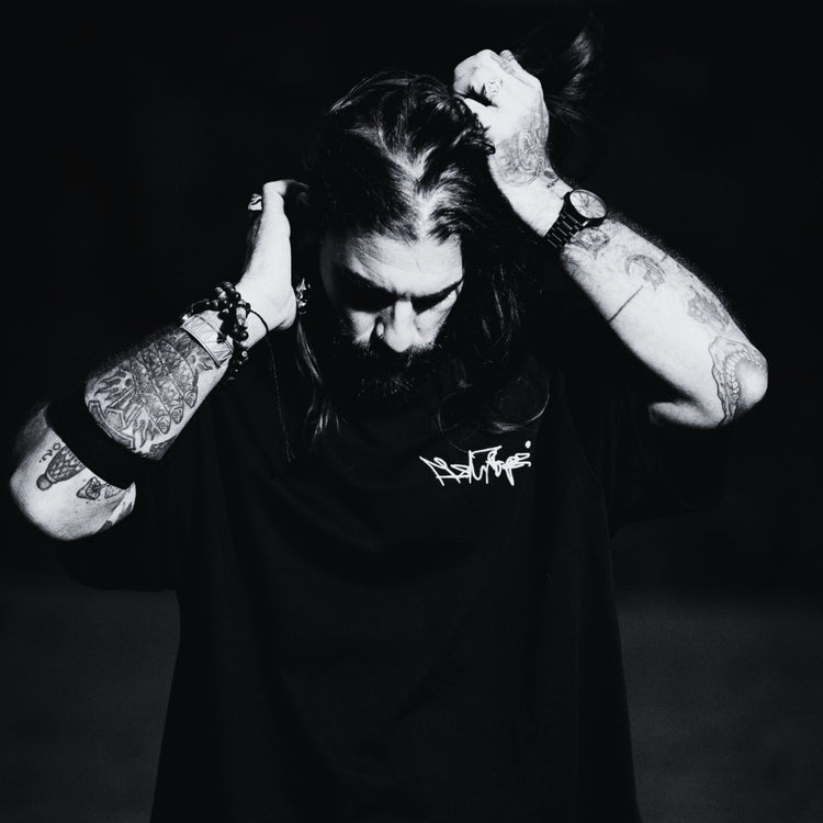 MSNTRPZ® MISANTHROPZ® Noir-Portrait eines langhaarigen tätowierten Models im schwarzen Premium Streetwear-Shirt | Premium German Streetwear