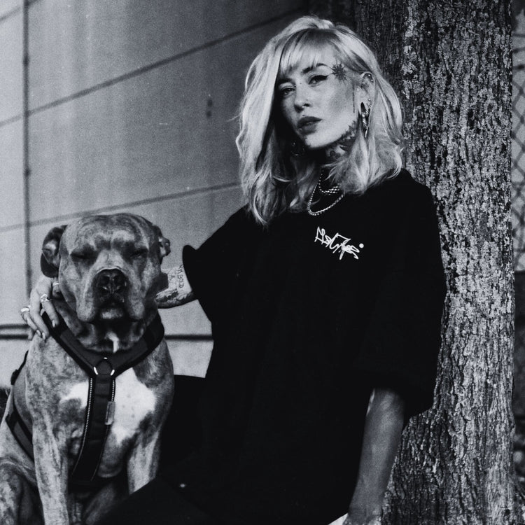 Frau mit Hund im Noir-Look trägt MISANTHROPZ® Premium Streetwear T-Shirt; urbaner Outsider-Stil