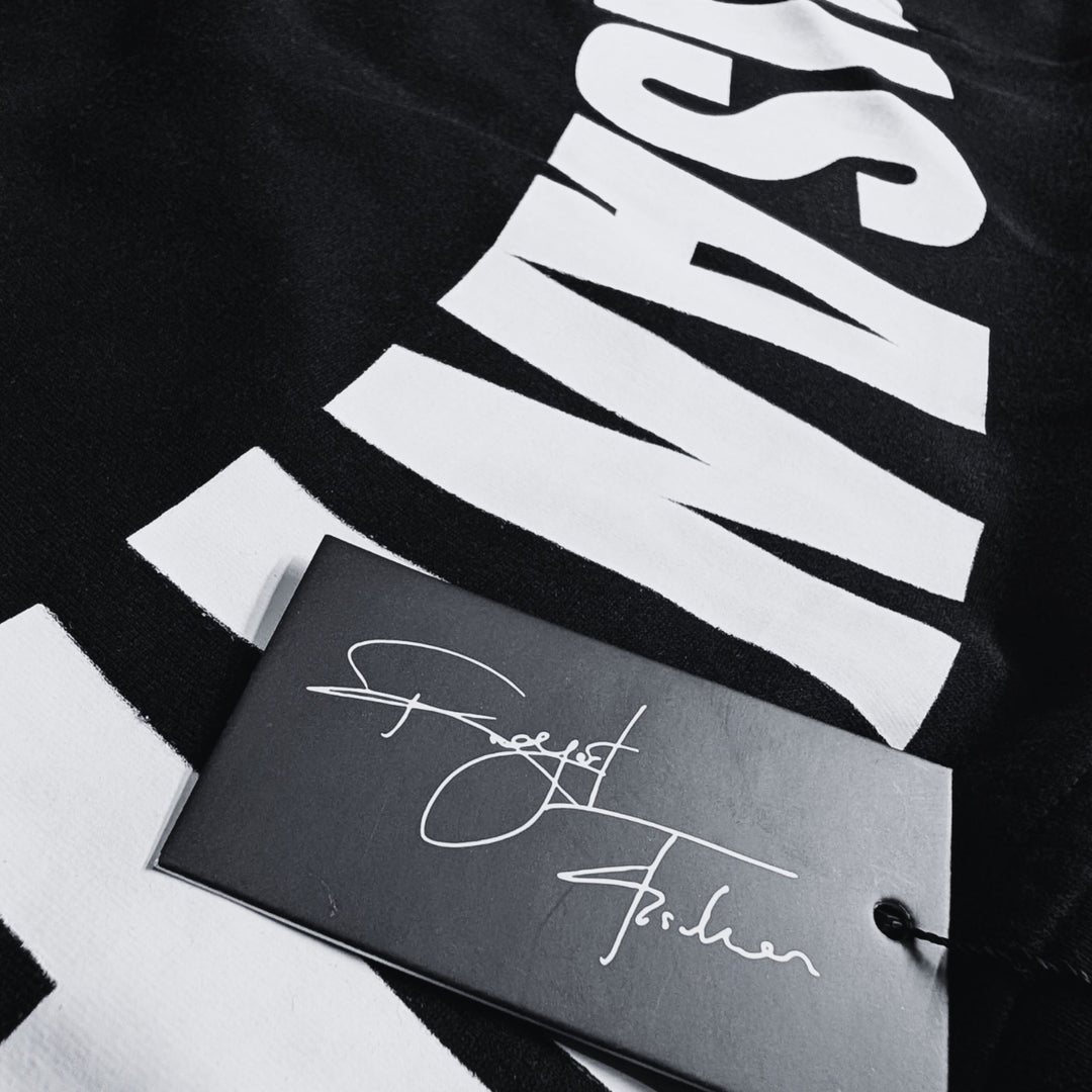 Detailaufnahme eines MSNTRPZ® MISANTHROPZ® Shirtprints mit großem weißen Schriftzug und schwarzem Hangtag mit Signature-Aufdruck im Noir-Stil | Premium German Streetwear
